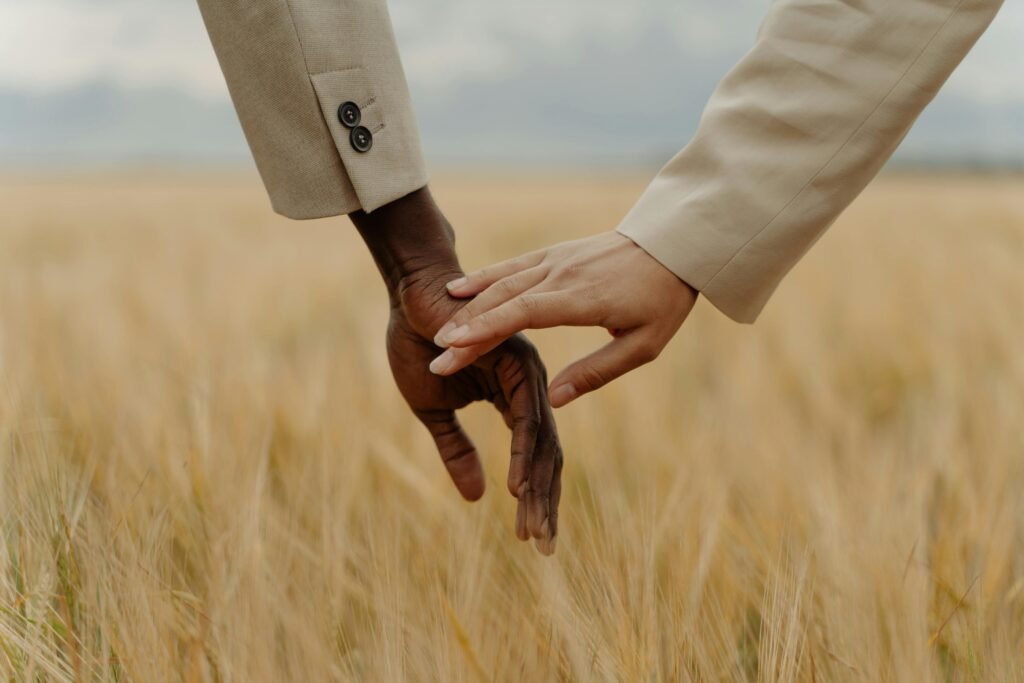 Diverse hands in fall field symbolize unity and connection.